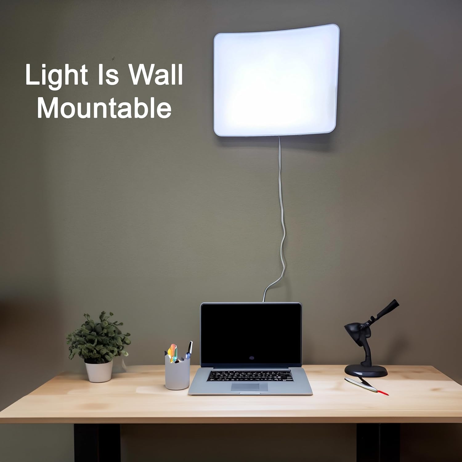 A white light therapy lamp hung from a wall over a desk. Text, "light is wall mountable"