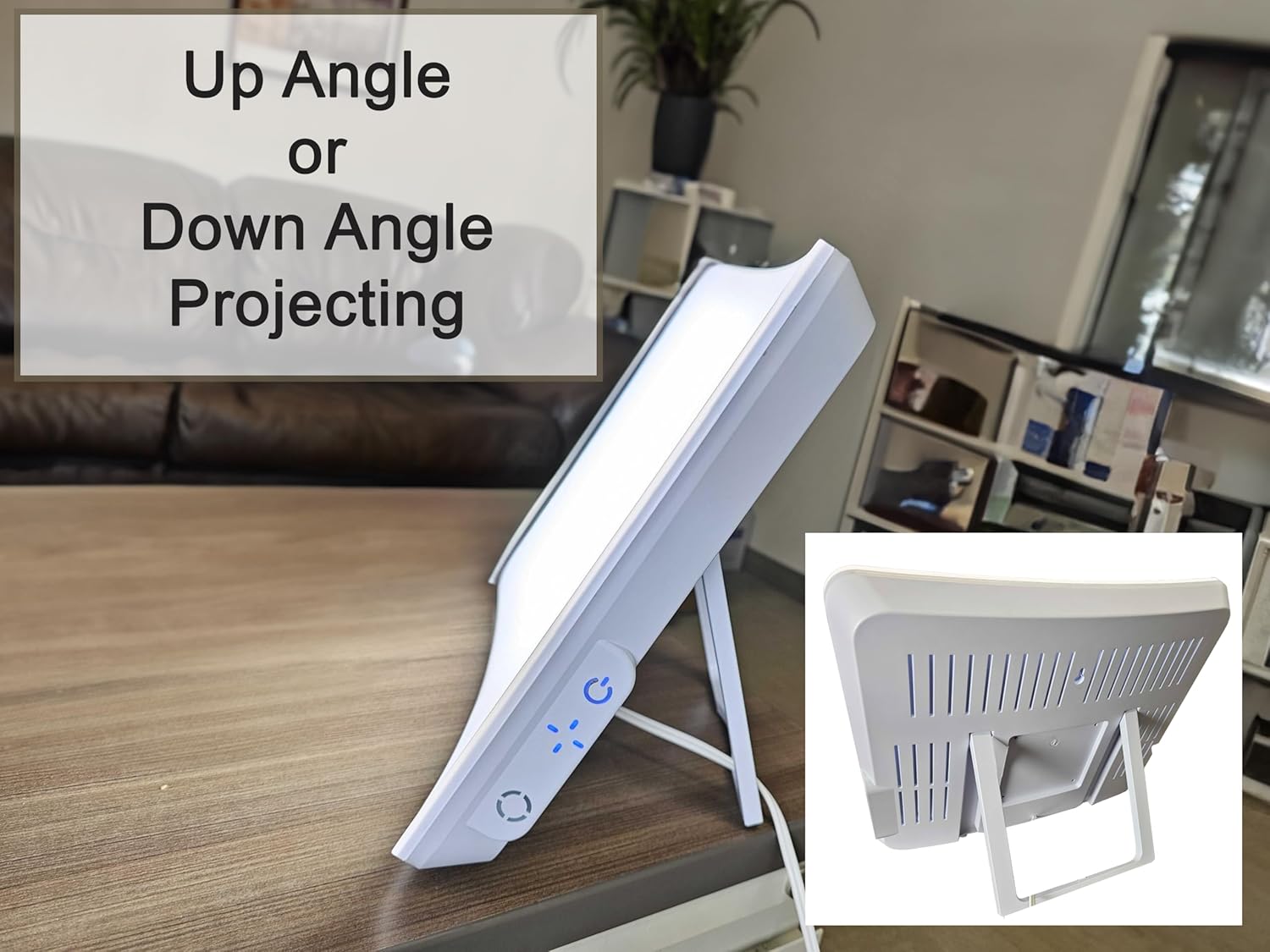 A white light therapy lamp sitting on a table. Text, "up angle or down angle projecting"