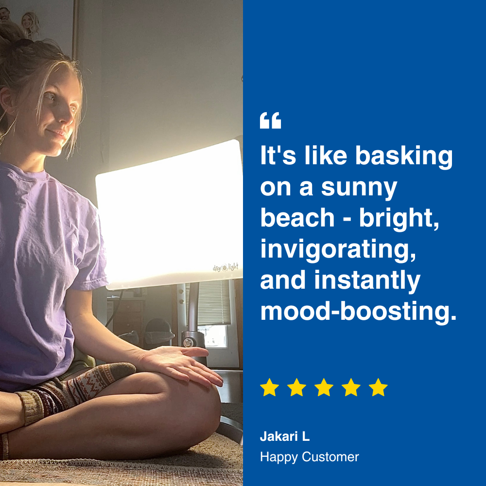 An image of a woman sitting next to a therapy lamp with review text